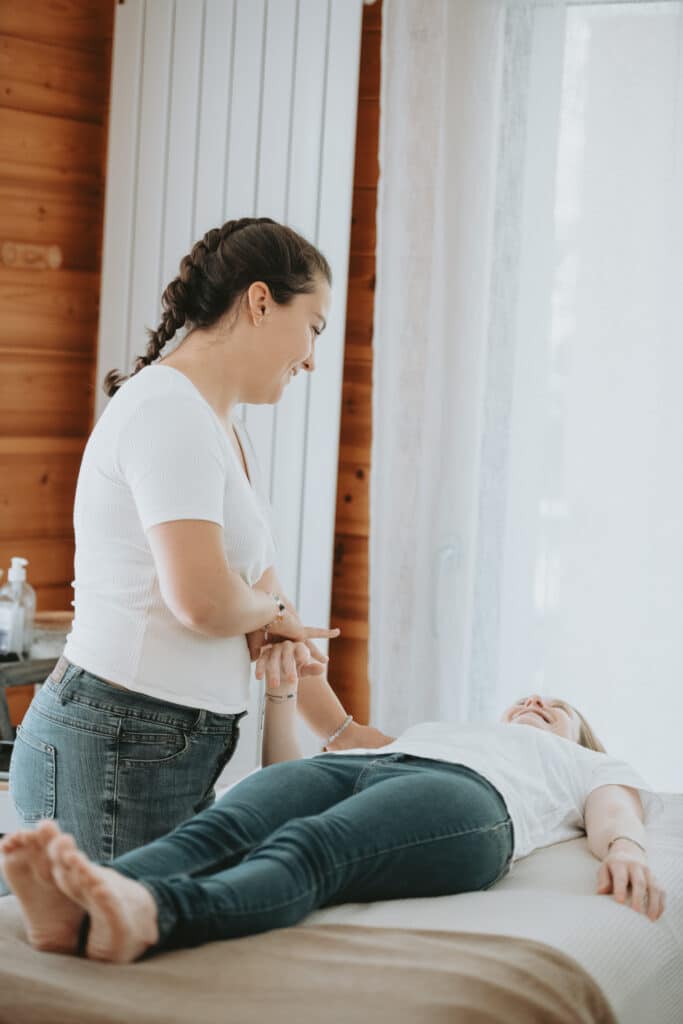 Test musculaire sur la jambe d'une cliente debout, dans le cabinet de Maëlys